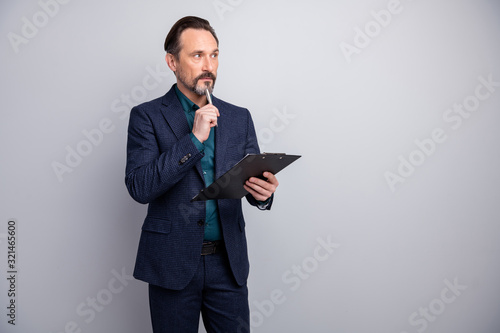 Photo of attractive clever business manager man read contract clipboard deep thinking doubtful agreement formalwear blazer shirt pants blue suit isolated grey color background