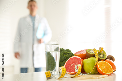 Healthy products  measuring tape and blurred nutritionist on background