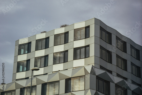 Geometric background with many window rows. Modern building structure. Many glasses on a huge wall. European classic skyscraper with copy space.