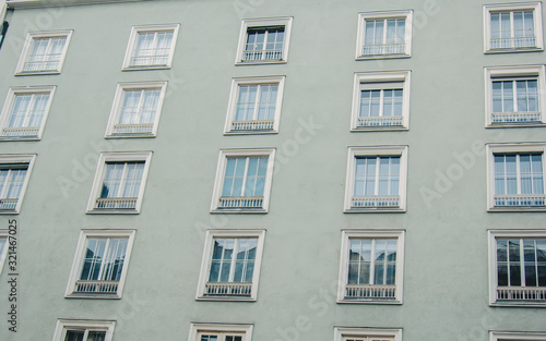 Geometric background with many window rows. Modern building structure. Many glasses on a huge wall. European classic skyscraper with copy space.