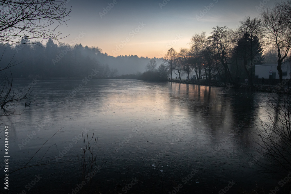 Fototapeta premium beautiful view on a frozen lake in winter season in beautiful sunset and mountains