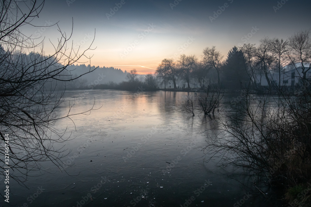 beautiful view on a frozen lake in winter season in beautiful sunset and mountains