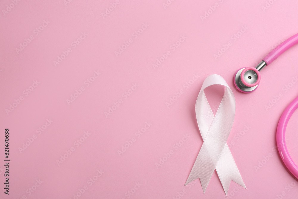 Pink ribbon and stethoscope on color background, flat lay with space for text. Breast cancer concept