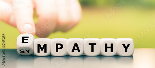 Hand turns dice and changes the word "sympathy" to "empathy".