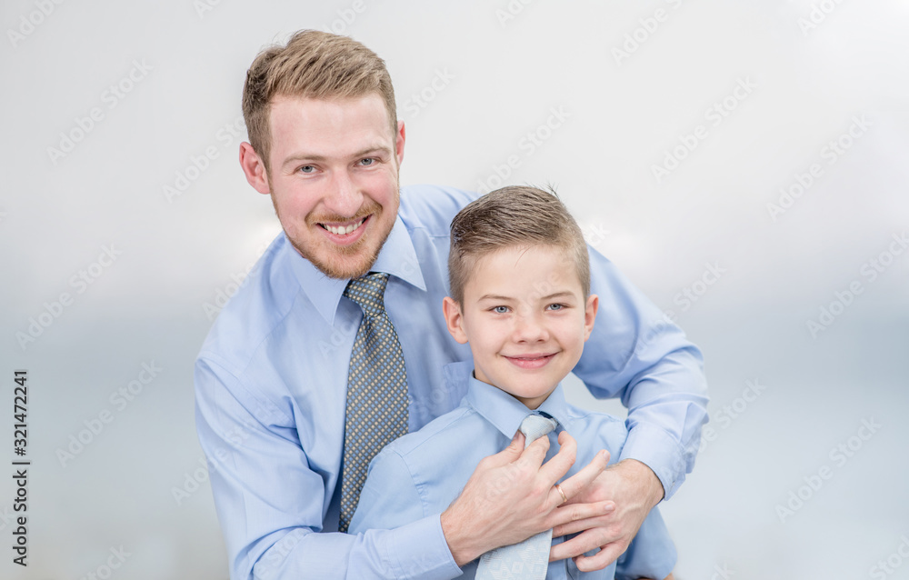 Smiling father helps his son to put his tie Smiling father helps his son to put his tie