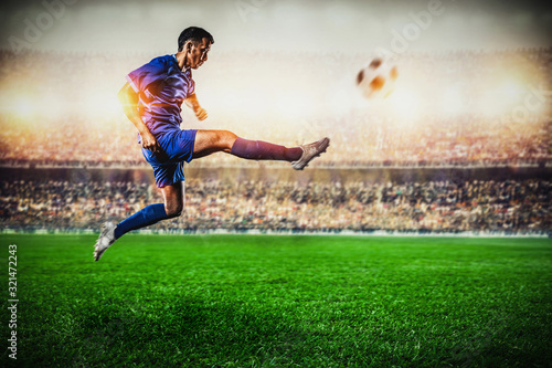 soccer player jumping and kicking the ball in the stadium © pixfly