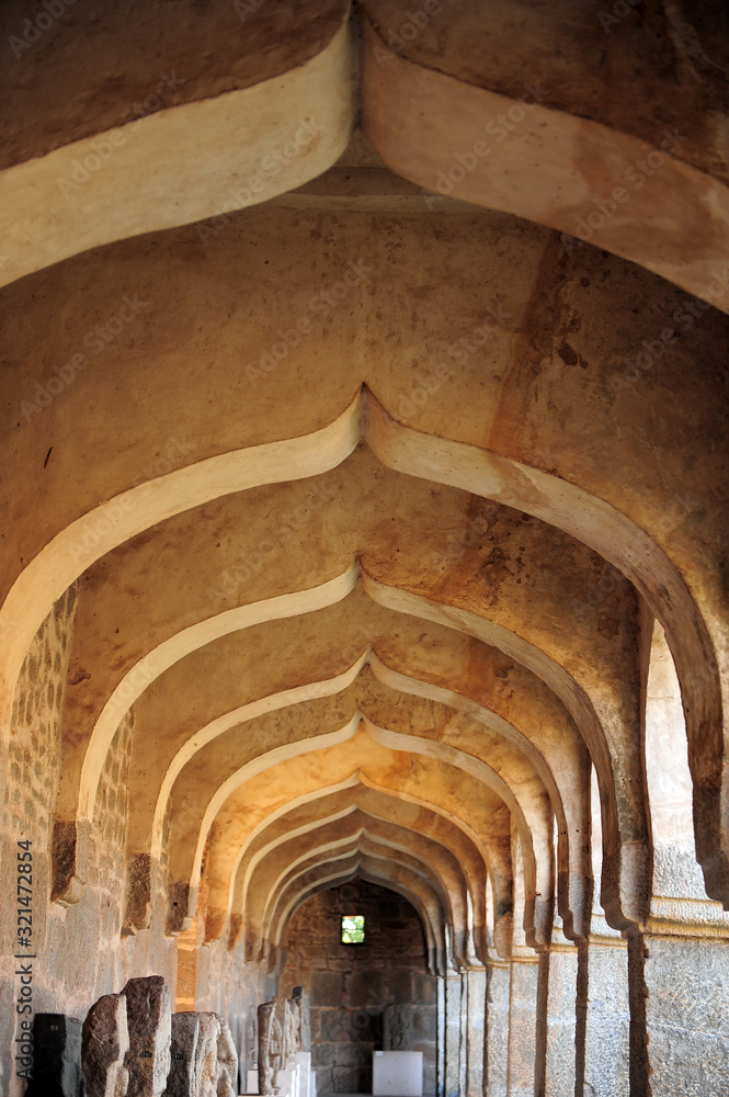 Arched hallway in the Hampi temple complex. Cultural heritage, ancient architecture of India.