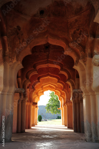 Intricate carvings on the arched hallway Lotus Mahal Temple in Hampi, Karnataka, India. Beautiful carved stone arch. Popular tourist place.