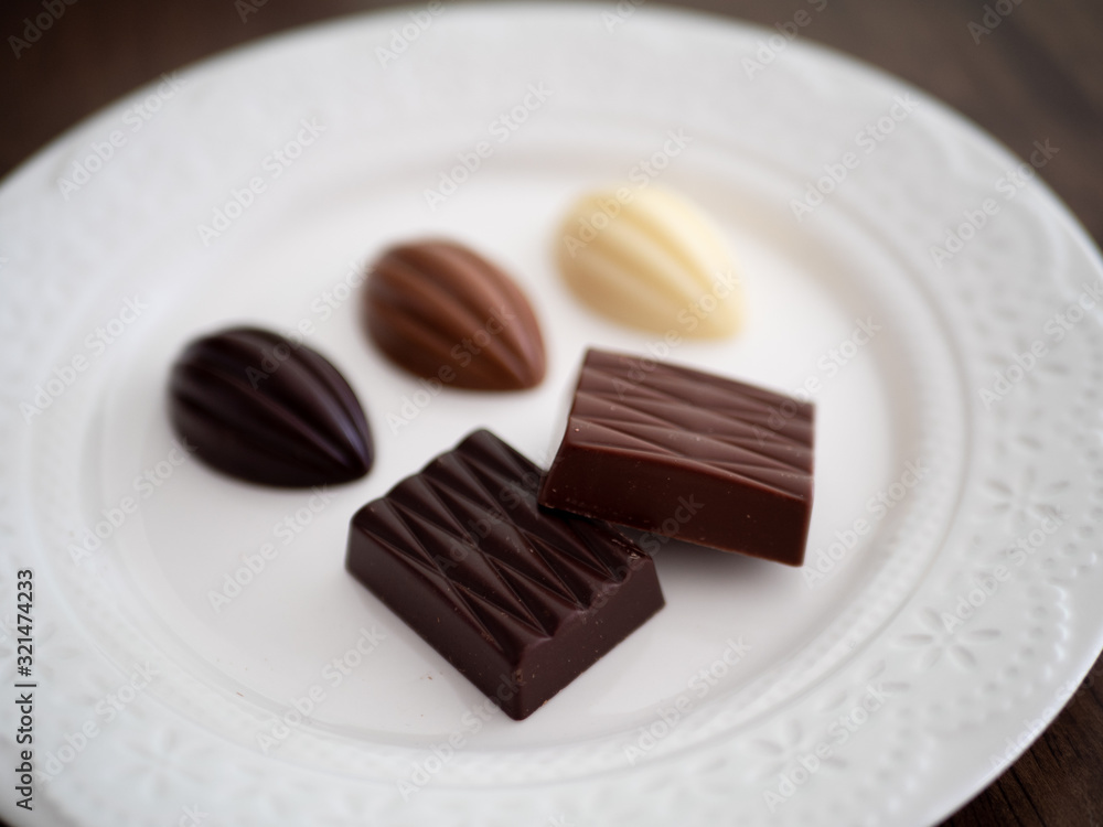 白いお皿の上に並べられた様々な種類のチョコレート 白いお皿の上に並べられた様々な種類のチョコレート