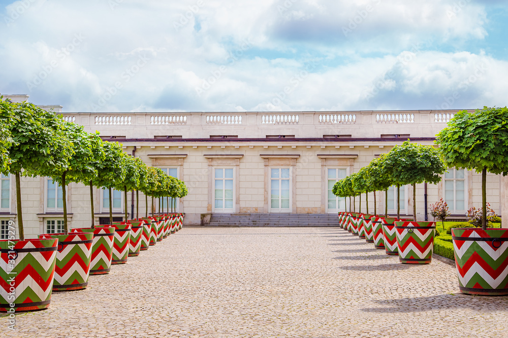 Fototapeta premium Castle gardens in front of Royal Castle in Warsaw, saxon facade Poland. Landscape design, park with shrubs and green lawns.