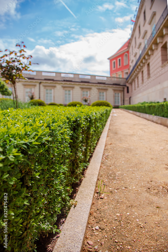 Castle gardens in front of Royal Castle in Warsaw, saxon facade Poland. Landscape design, park with shrubs and green lawns.