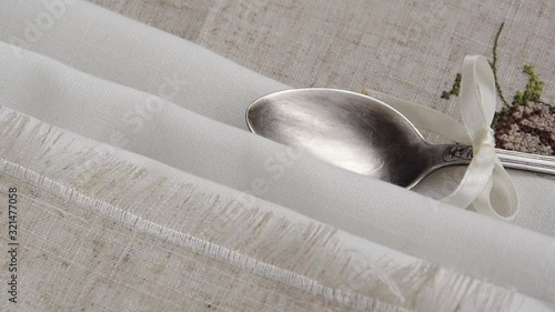 Vintage russian silverspoon with silk ribbon on linen napkin. Old fashion heroloom silverware photo