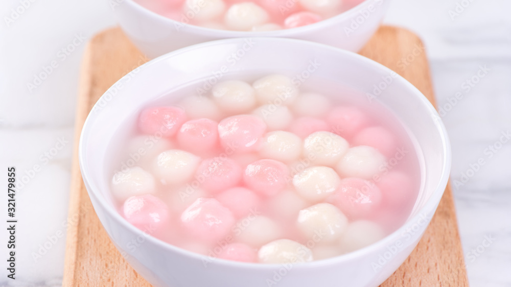 Tang yuan, tangyuan, delicious red and white rice dumpling balls in a small bowl. Asian traditional festive food for Chinese Winter Solstice Festival, close up. Tang yuan, tangyuan, delicious red and white rice dumpling balls in a small bowl. Asian traditional festive food for Chinese Winter Solstice Festival, close up.