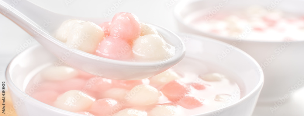 Tang yuan, tangyuan, delicious red and white rice dumpling balls in a small bowl. Asian traditional festive food for Chinese Winter Solstice Festival, close up. Tang yuan, tangyuan, delicious red and white rice dumpling balls in a small bowl. Asian traditional festive food for Chinese Winter Solstice Festival, close up.