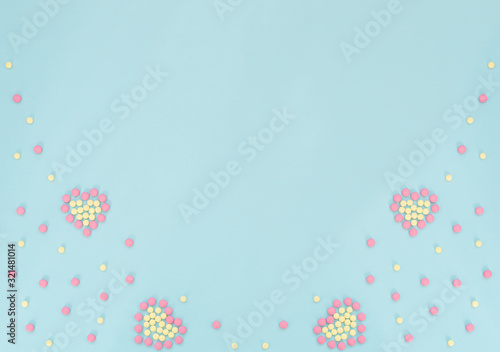 Hearts made of pink and yellow pills on light blue background. Seasonal diseases. Medicine concept. Flat lay style with copy space  top view.