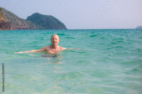 mature man swims in the sea