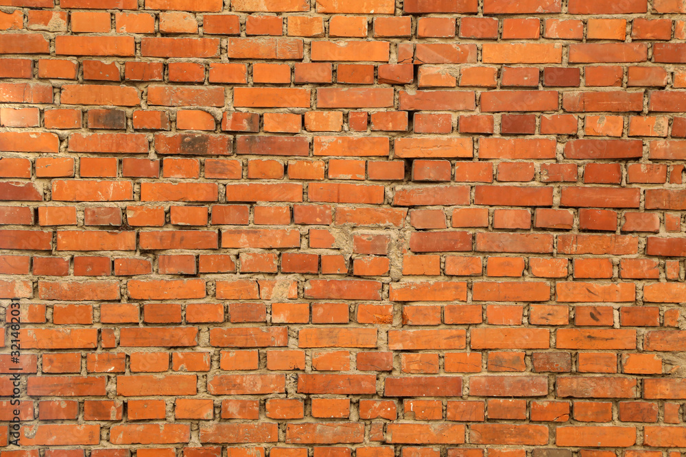 Naklejka premium Old brick wall, old texture of red stone blocks closeup