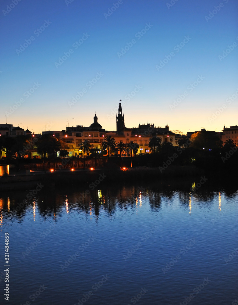 Amanecer en Sevilla con la silueta de la torre Giralda en el centro de la imagen, España