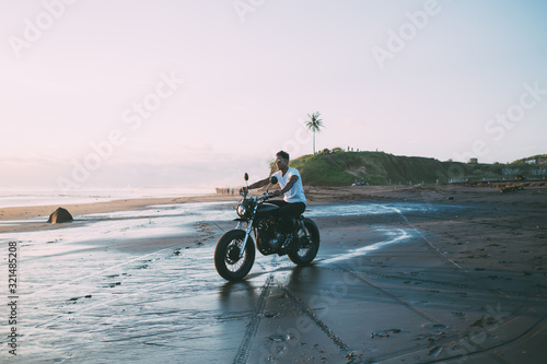 Young man riding motorbike on seashore