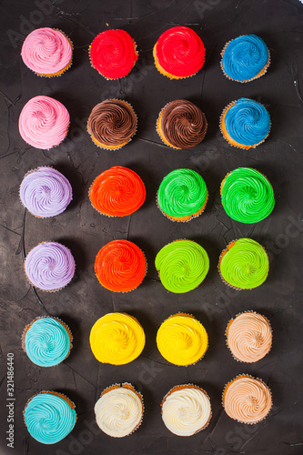 The lot of delicious multi-colored cupcakes closeup