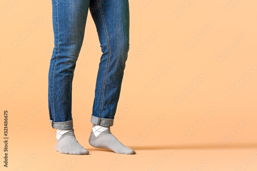 Male legs in socks and jeans on color background Male legs in socks and jeans on color background