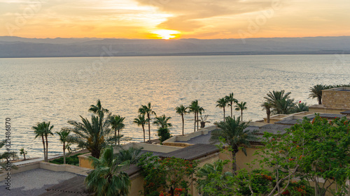 Magic sunset at the Dead Sea in Jordan. Sea view through coastline of hotel. Through Dead Sea coast of Israel is visible. Resort and tourism theme. Dead Sea, Jordan - May 22, 2011
