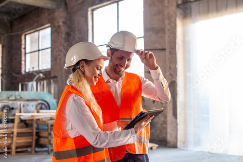 Business people in protection helmet and jacket discussing a new construction project