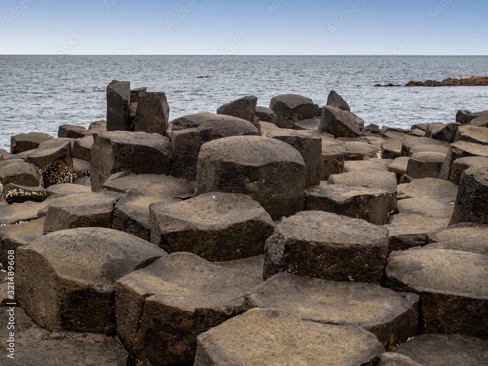 Giant’s Causeway,  Northern Ireland, UK. Unique natural hexagonal and pentagonal geological formations of volcanic basalt rocks, resembling cobblestones