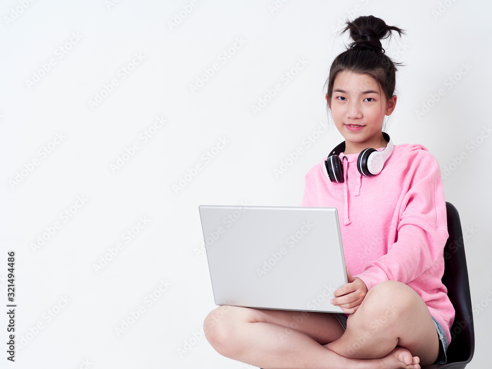 Cheerful girl using laptop sitting on chair. Cheerful girl using laptop sitting on chair.