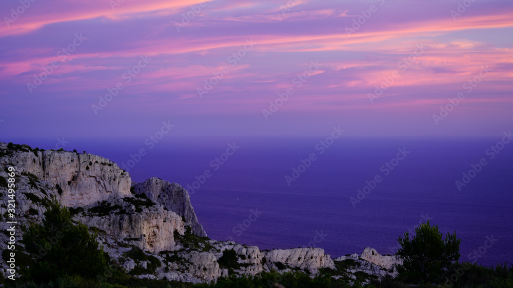 Purple sea and mountain with a colorful sunset; beautiful scene of the sea at sunset