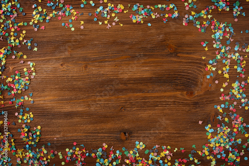 Colorful confetti on wooden texture