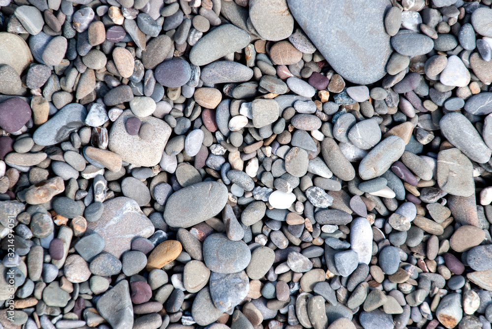 background of pebbles on a gray and brown beach background of pebbles on a gray and brown beach