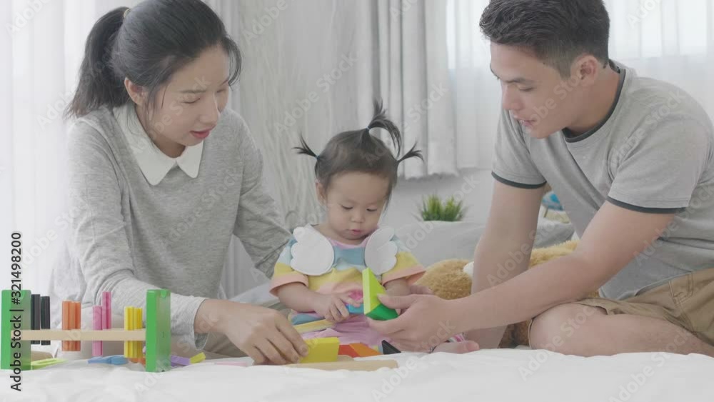 Happy family times , Asian parents playing ant teaching daughter at home together Happily. Happy family times , Asian parents playing ant teaching daughter at home together Happily.