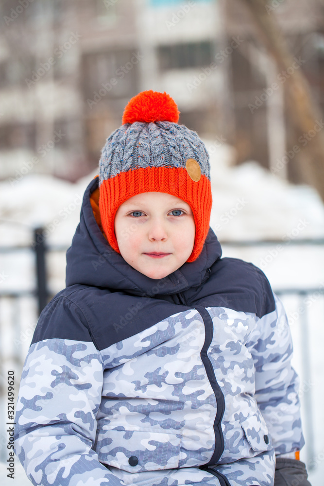 Portrait of a little boy in a red knitted hat in winter park Portrait of a little boy in a red knitted hat in winter park