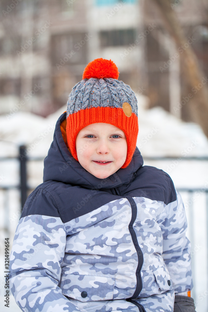 Portrait of a little boy in a red knitted hat in winter park Portrait of a little boy in a red knitted hat in winter park