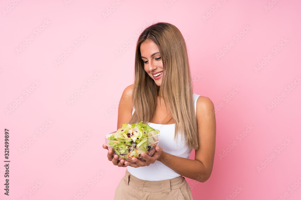 Young blonde woman with salad over isolated background Young blonde woman with salad over isolated background