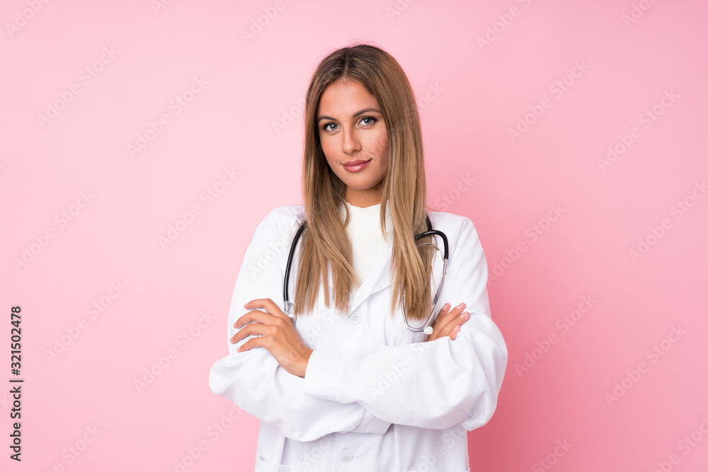 Young blonde woman over isolated pink background with doctor gown Young blonde woman over isolated pink background with doctor gown