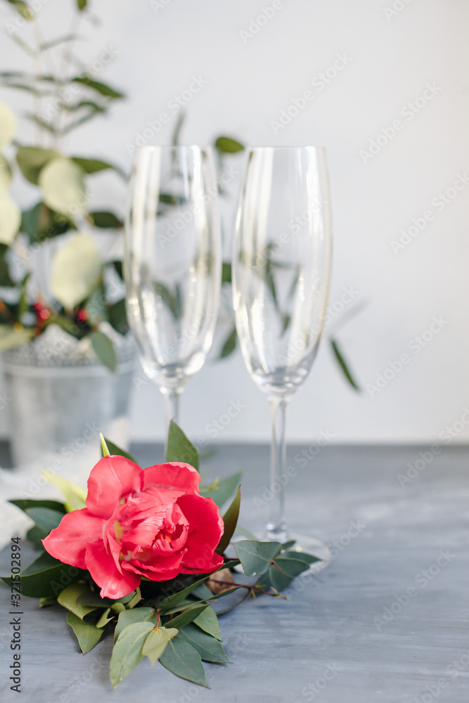 Composition with glass for champagne. Flowers and hearts on grey concrete background. Composition with glass for champagne. Flowers and hearts on grey concrete background.