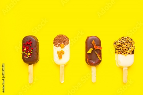 Popsicles on yellow background. Mini dessert close up