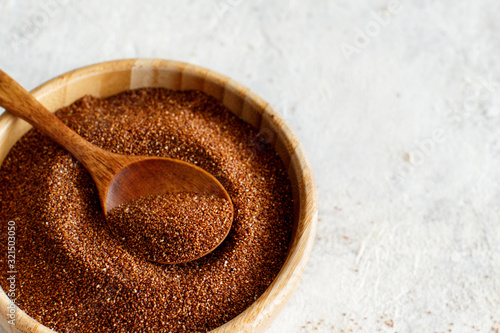 Raw teff grain in a wooden bowl close up photo