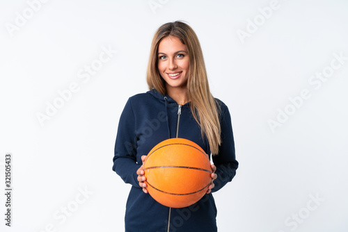 Young woman playing basketball over isolated white background