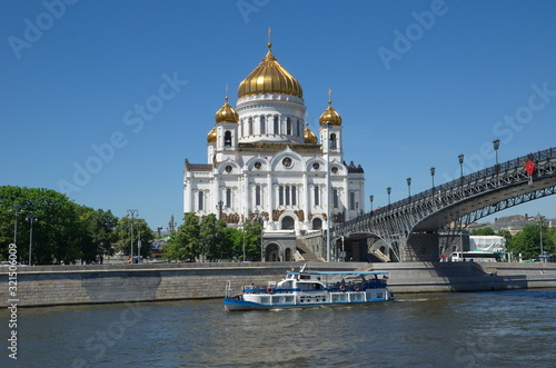 Summer view of the Cathedral of Christ the Saviour, the Patriarchal bridge and a pleasure boat sailing on the Moscow river. Moscow, Russia