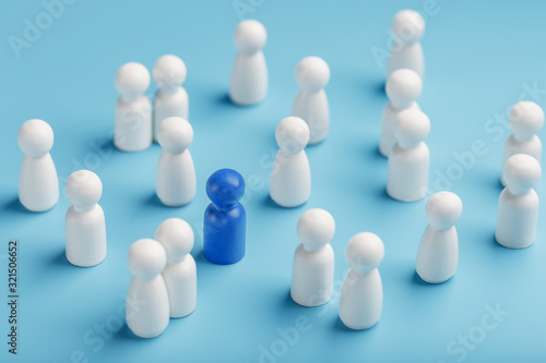The leader of the blue color stands among the crowd, a group of white employees. The concept of leadership. Many employees are drawn to their boss. Personnel selection.