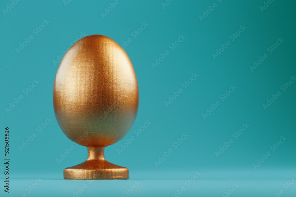 Golden egg on a blue background with a minimalistic concept. Space for text. Easter egg design templates. Stylish decor with minimal concept. Golden egg on a blue background with a minimalistic concept. Space for text. Easter egg design templates. Stylish decor with minimal concept.