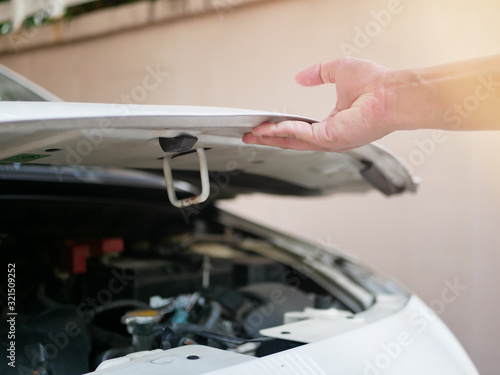 hand of a man opening the bonnet To check general car conditions, Engine, oil, radiator.