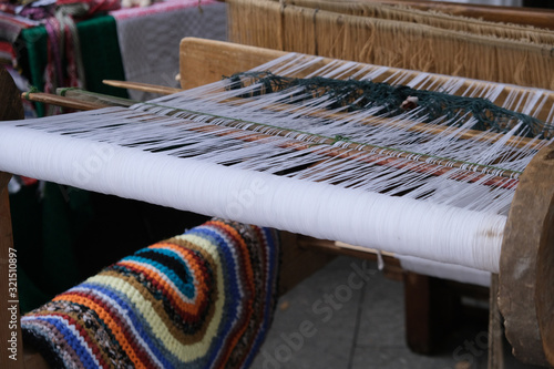 A spinning wheel with yarn baskets and old chair