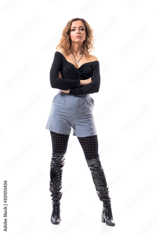Cocky attitude brunette curly hair fashionable woman with crossed hands looking at camera. Full body length isolated on white background. Cocky attitude brunette curly hair fashionable woman with crossed hands looking at camera. Full body length isolated on white background.
