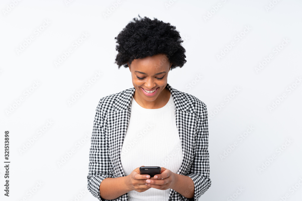 African american woman with blazer over isolated white background sending a message with the mobile African american woman with blazer over isolated white background sending a message with the mobile