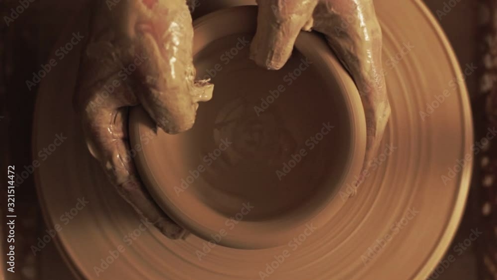 Pottery craft. Handmade ceramics manufacturing. Man hands shaping clay bowl with fingers on wheel. Pottery craft. Handmade ceramics manufacturing. Man hands shaping clay bowl with fingers on wheel.