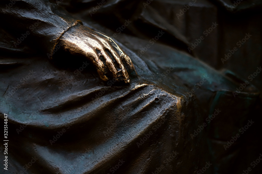 a bronze hand on the knee is an element of the sculpture